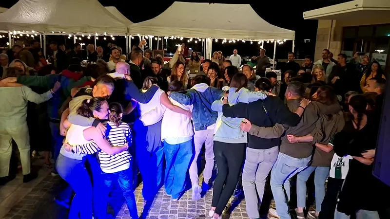 Ronde d'invités enlacés sur la piste pendant la soirée d'un mariage