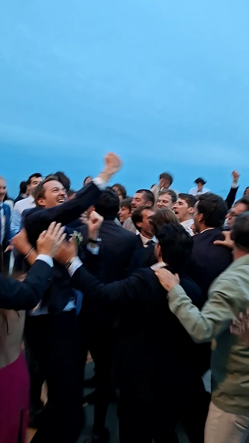 Groupe d'invités bras levés sur la piste de danse en extérieur pendant une soirée de mariage