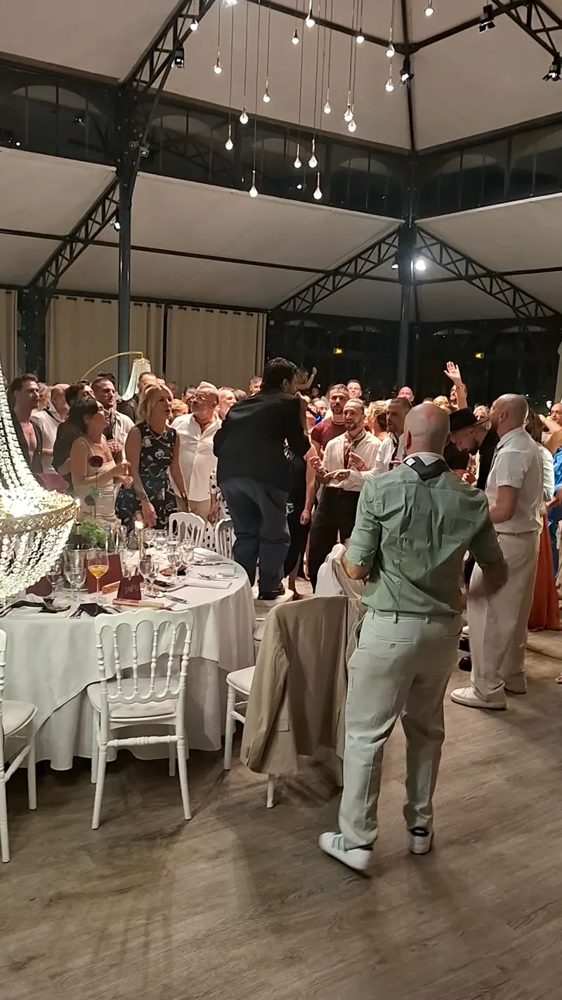 Tables dressées et lustres en cristal pendant la soirée dansante d'un mariage
